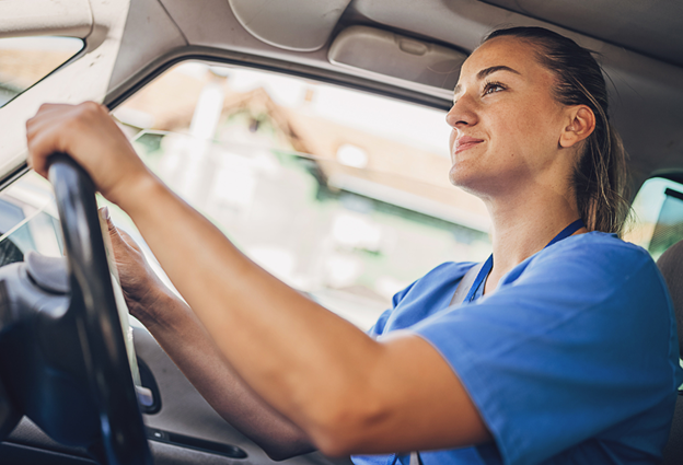 A shift worker driving to work and considering the costs and coverage of electric car insurance before switching to an EV.